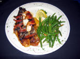 Blackened Fish served on a bed of roasted roma tomatoes and topped with red bell peppers, portobello mushrooms and shrimp.